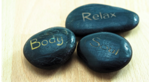 Three black stones with the words "body", "relax", "soul".